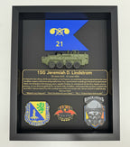 Framed military display with a blue flag, text, and various insignias.