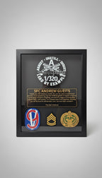 Framed military plaque with various insignias and text on a wooden surface