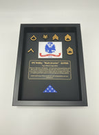 Framed military plaque with insignia and text on a black background