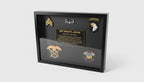 Framed military plaque with insignias and text on a table