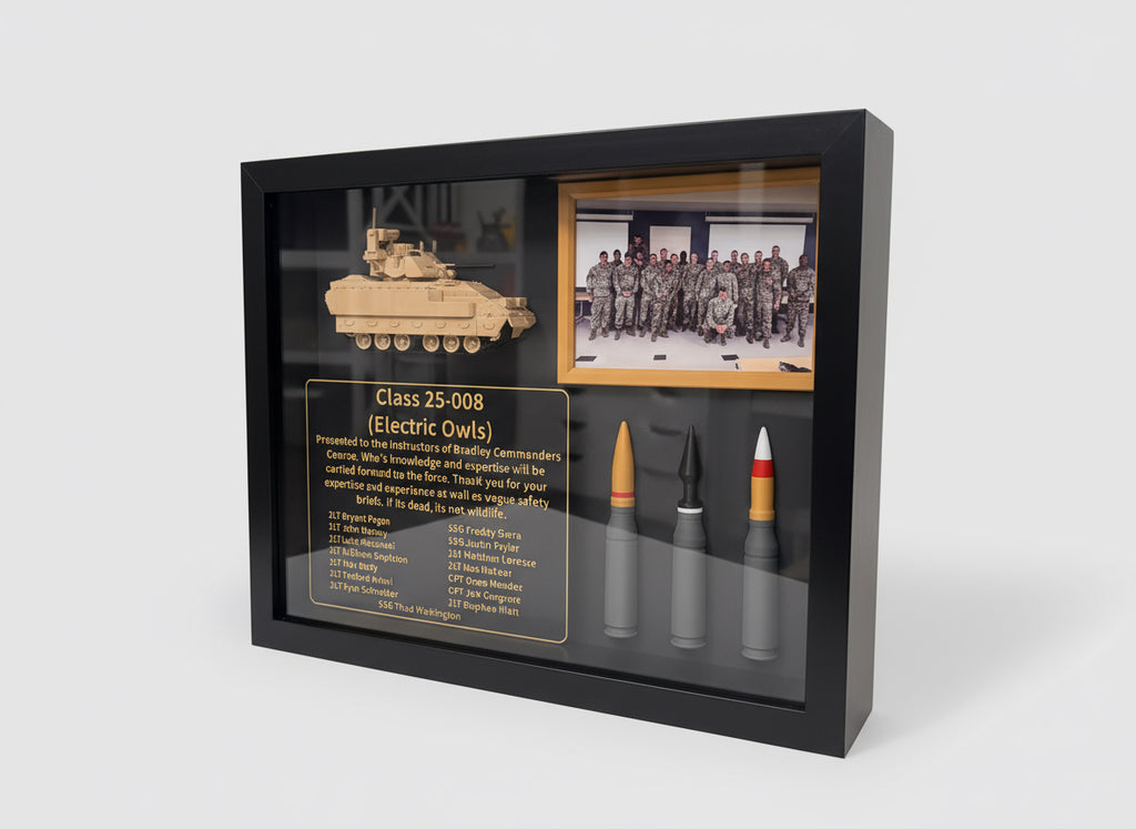 Framed display with a model tank, bullet, and photo of soldiers on a white surface.