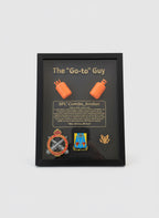 Framed recognition plaque with military insignia and text held by a person.